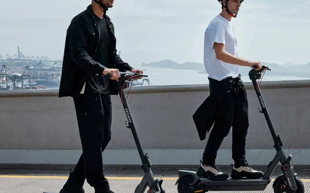 Two riders on Segway e-scooters by the water